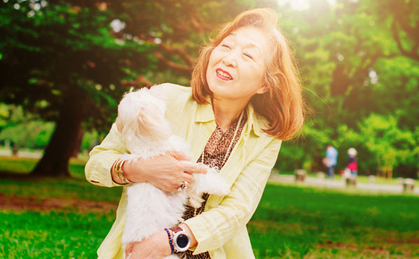 Woman smiling with her pet outdoors